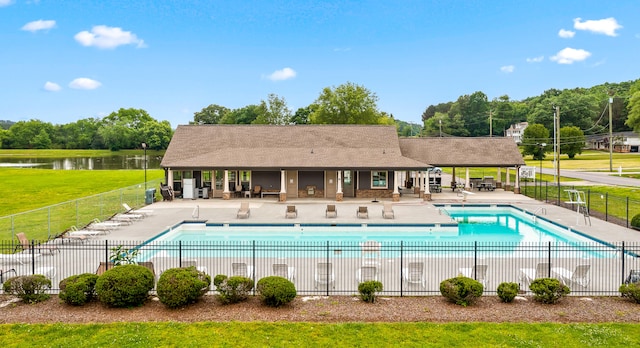 view of swimming pool featuring a yard, a water view, and a patio