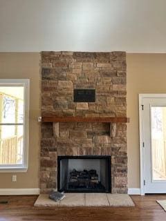 room details with hardwood / wood-style floors and a stone fireplace