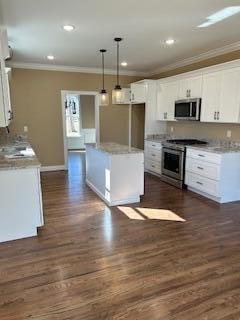 kitchen featuring pendant lighting, white cabinetry, crown molding, and appliances with stainless steel finishes