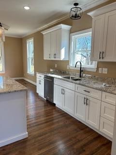 kitchen with sink, white cabinets, a chandelier, and ornamental molding