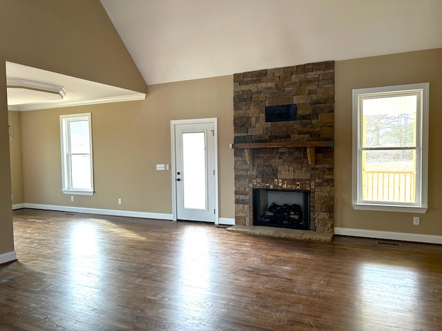 unfurnished living room featuring ornamental molding, a stone fireplace, dark wood-type flooring, and high vaulted ceiling