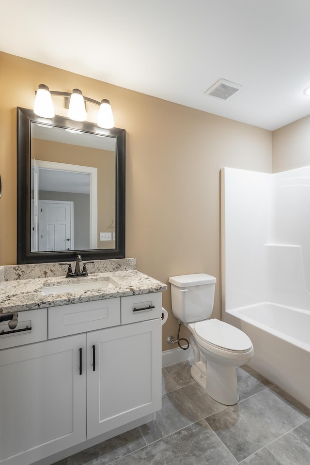 full bath featuring toilet, vanity, visible vents, baseboards, and washtub / shower combination