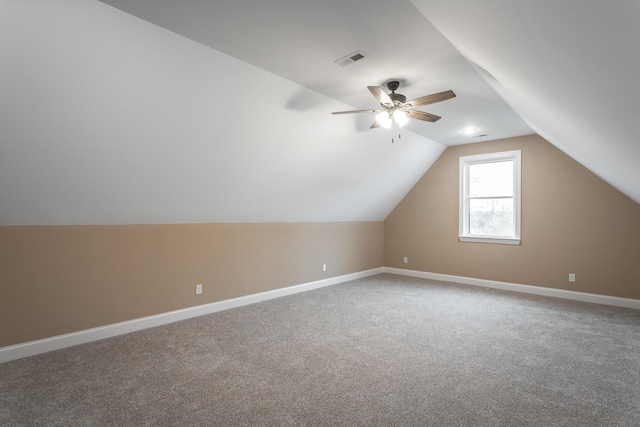 additional living space featuring baseboards, visible vents, ceiling fan, vaulted ceiling, and carpet flooring