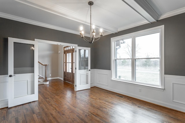 unfurnished dining area with dark wood-style floors, a wainscoted wall, visible vents, beamed ceiling, and stairs