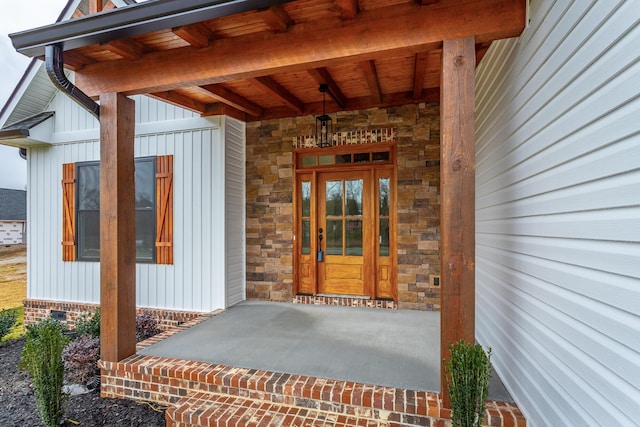 entrance to property with board and batten siding and stone siding