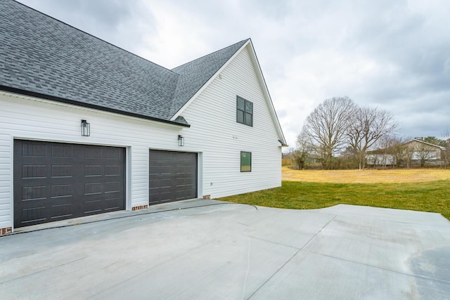 view of home's exterior with driveway, a yard, and roof with shingles