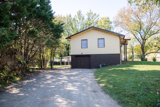 view of side of home with a yard and a garage