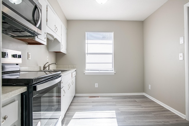 kitchen featuring white cabinetry, light hardwood / wood-style floors, appliances with stainless steel finishes, and sink