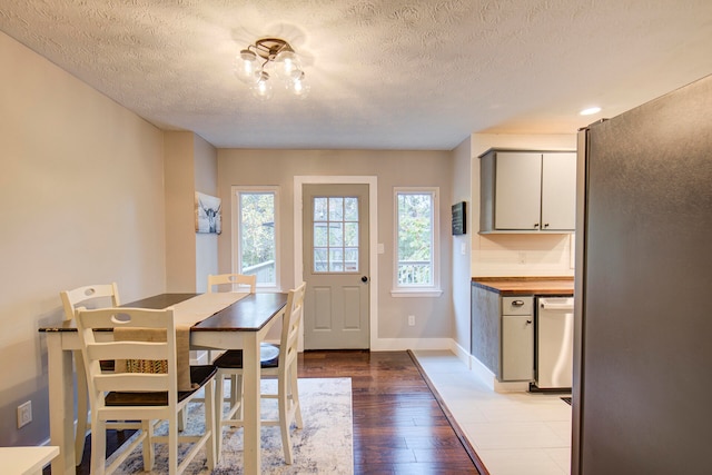 dining space featuring a textured ceiling and light hardwood / wood-style flooring