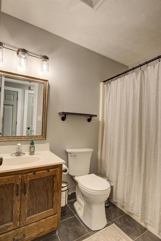 bathroom featuring toilet, a textured ceiling, tile patterned flooring, vanity, and a shower with shower curtain