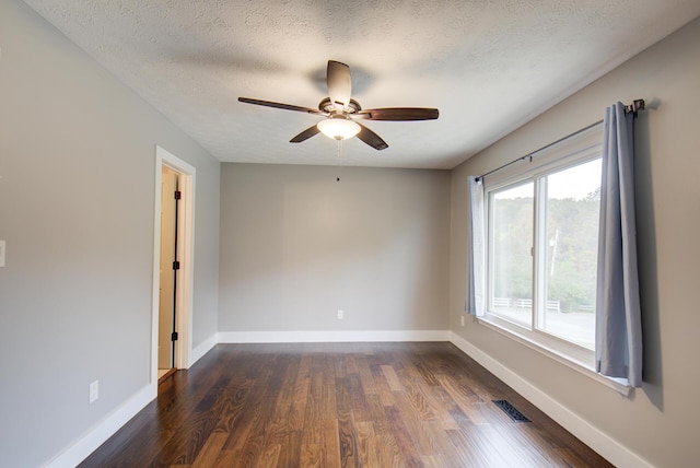 empty room with dark wood-style floors, a ceiling fan, baseboards, and a textured ceiling