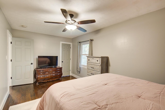 bedroom featuring dark wood-type flooring, baseboards, and a ceiling fan