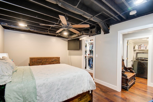 bedroom with a closet, ceiling fan, a spacious closet, and dark hardwood / wood-style floors