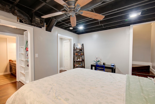 bedroom featuring hardwood / wood-style floors, ensuite bathroom, and ceiling fan