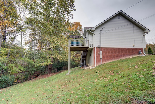 view of side of property featuring a wooden deck and a lawn