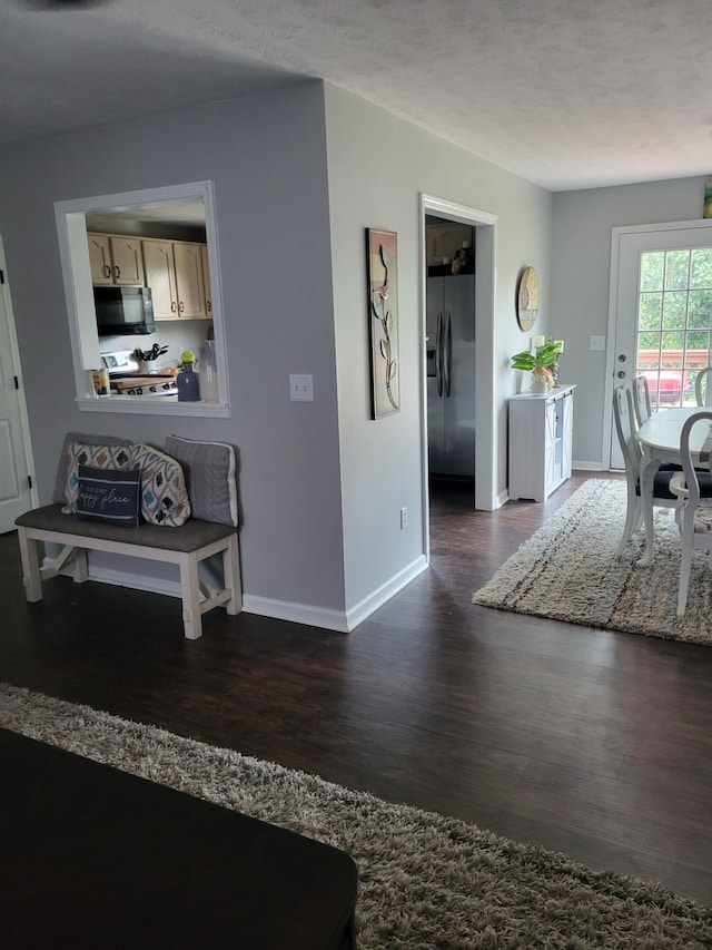 interior space with a textured ceiling and dark hardwood / wood-style flooring