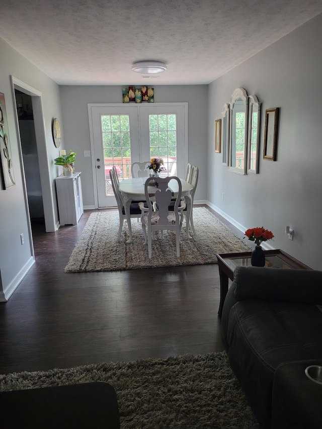 dining area featuring a textured ceiling and dark hardwood / wood-style flooring