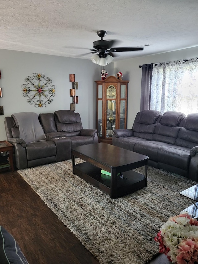 living room featuring a textured ceiling, hardwood / wood-style floors, and ceiling fan