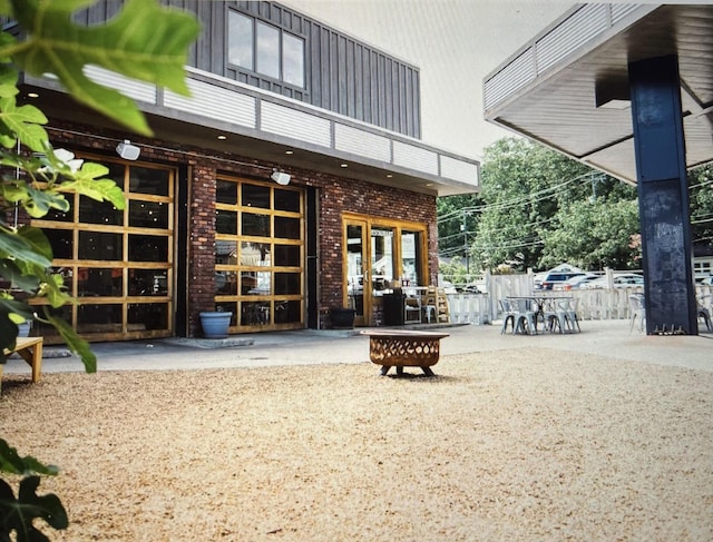 back of house with a fire pit and a patio