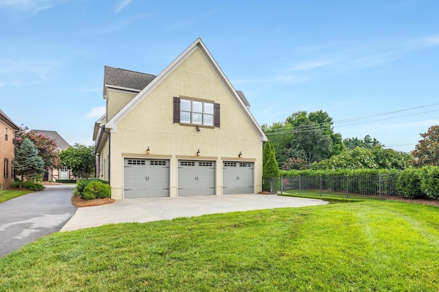 view of side of property featuring a garage and a lawn