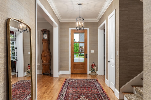 entrance foyer with light hardwood / wood-style floors, crown molding, and a chandelier