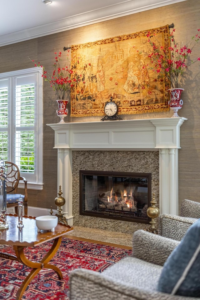 sitting room with ornamental molding and a fireplace