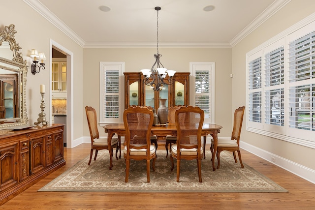 dining space with wood-type flooring, crown molding, and a chandelier