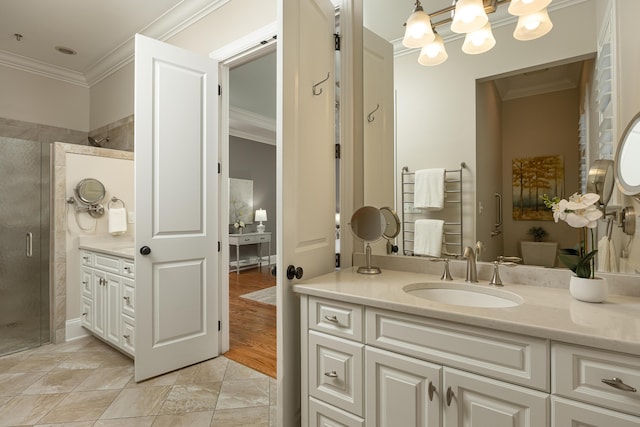 bathroom featuring a shower with door, vanity, crown molding, and a chandelier