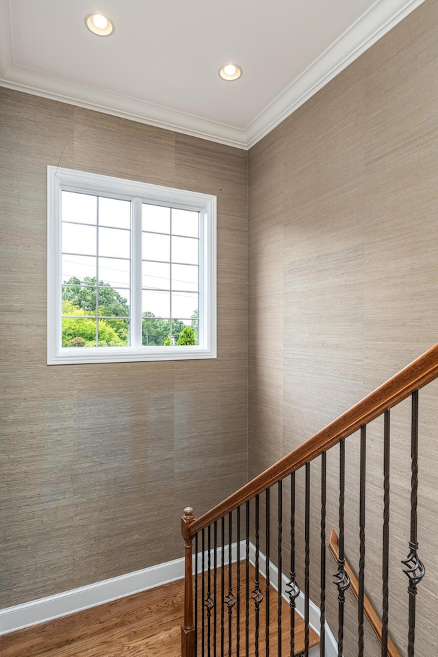 stairs featuring wood-type flooring and ornamental molding