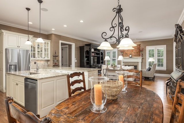 dining space with dark hardwood / wood-style flooring, sink, and ornamental molding