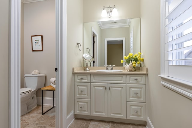 bathroom featuring toilet, vanity, and crown molding