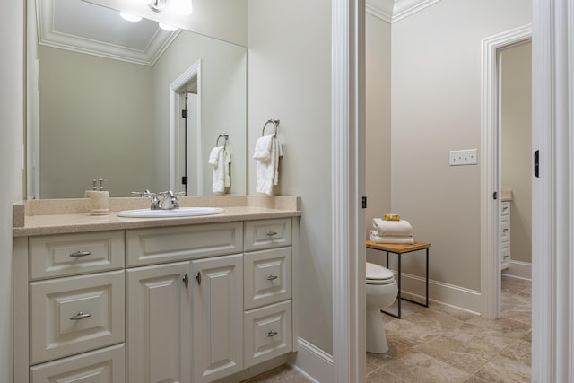 bathroom featuring toilet, vanity, and ornamental molding