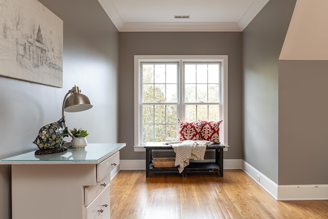 sitting room with light hardwood / wood-style floors and crown molding