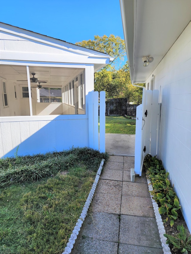 view of property exterior with a yard and ceiling fan