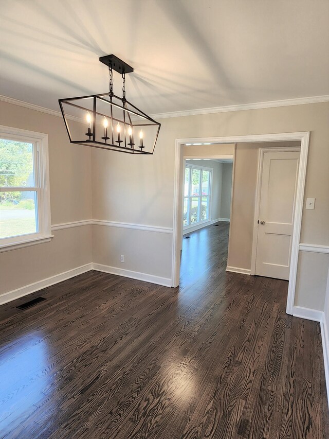 unfurnished dining area featuring a wealth of natural light, dark wood-type flooring, and crown molding