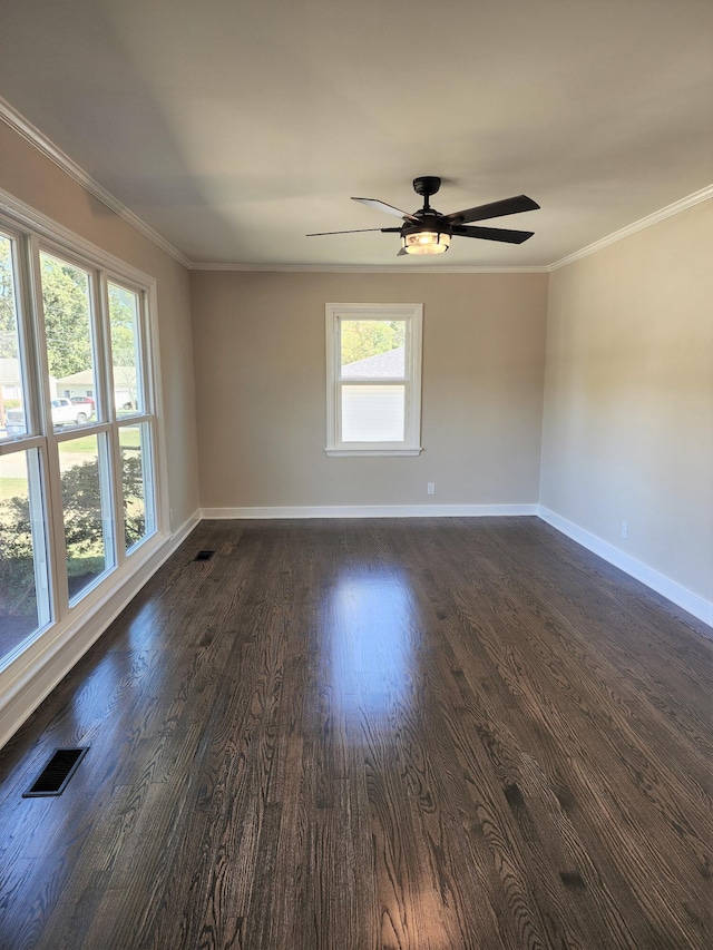 empty room with crown molding, a healthy amount of sunlight, and dark hardwood / wood-style flooring