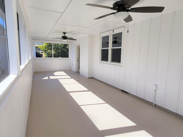 unfurnished sunroom with ceiling fan