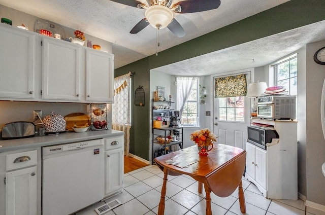 kitchen with ceiling fan, light tile patterned floors, white cabinetry, a textured ceiling, and dishwasher