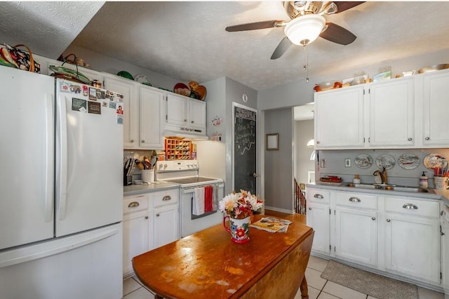 kitchen featuring white cabinets, light tile patterned floors, a textured ceiling, sink, and white appliances