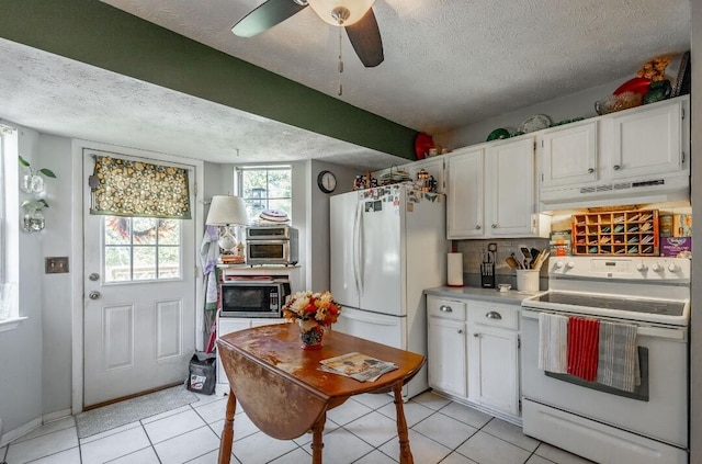 kitchen featuring custom exhaust hood, white cabinets, a textured ceiling, and white appliances