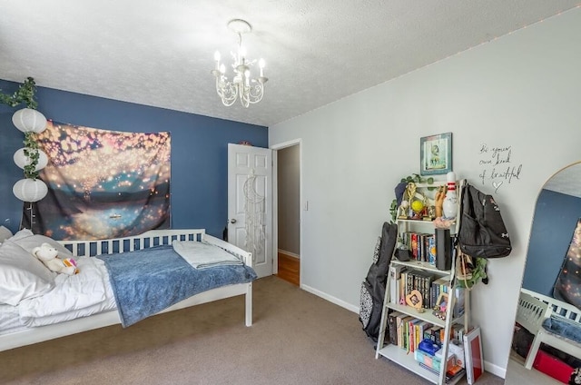 bedroom with a textured ceiling, a chandelier, and carpet