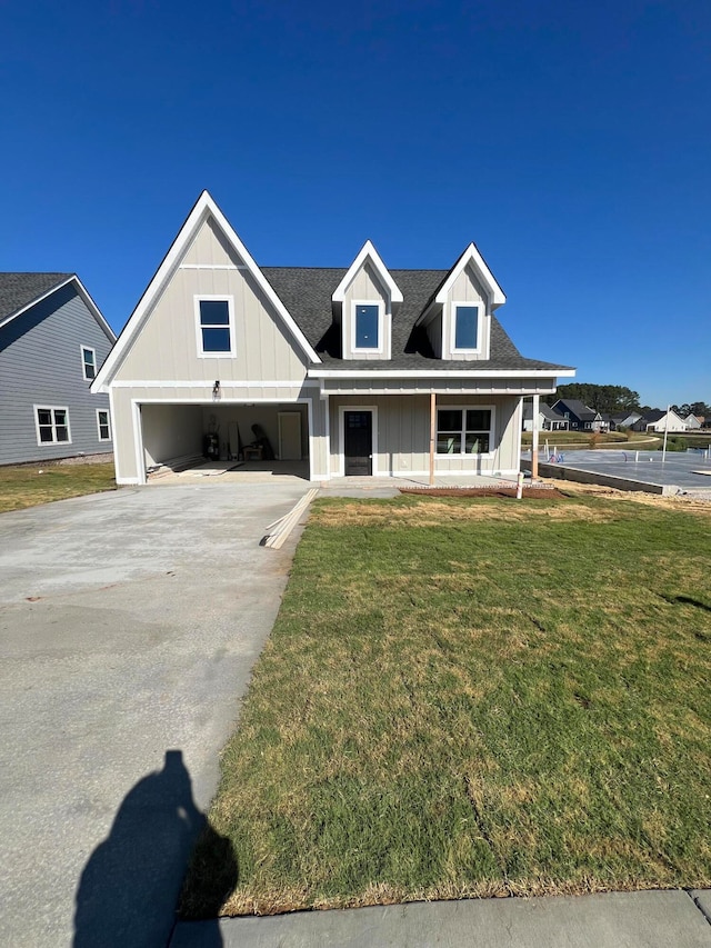 view of front of home featuring a front yard, a porch, and a garage