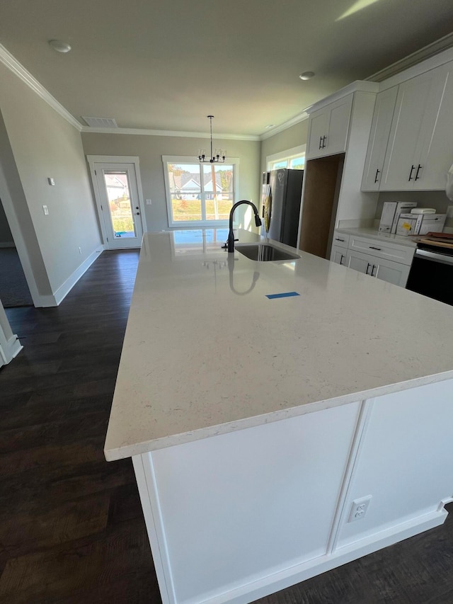 kitchen featuring dark hardwood / wood-style flooring, stainless steel fridge, white cabinets, and an island with sink