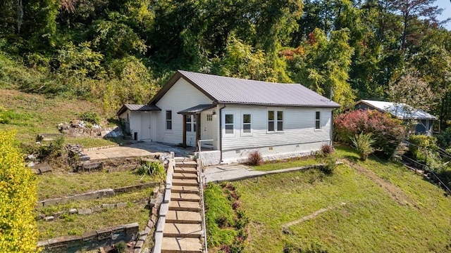 view of front of property featuring crawl space, a front lawn, and metal roof