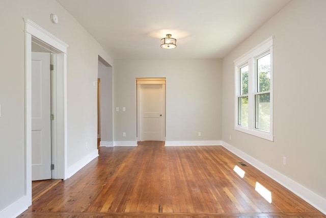 unfurnished room with hardwood / wood-style flooring