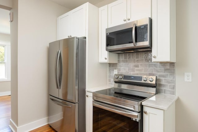 719 Federal St, Chattanooga, TN 37405 - kitchen featuring light wood-style flooring, appliances with stainless steel finishes, light countertops, backsplash, and baseboards