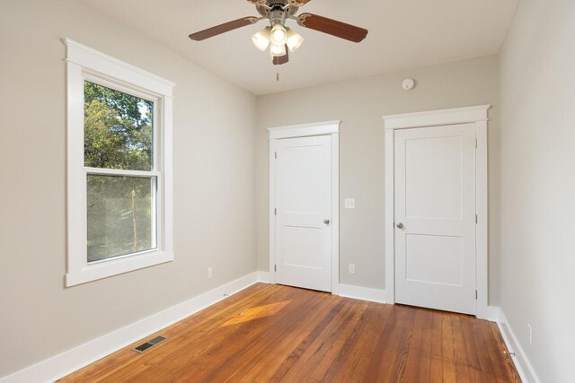 unfurnished bedroom featuring dark wood-type flooring and ceiling fan