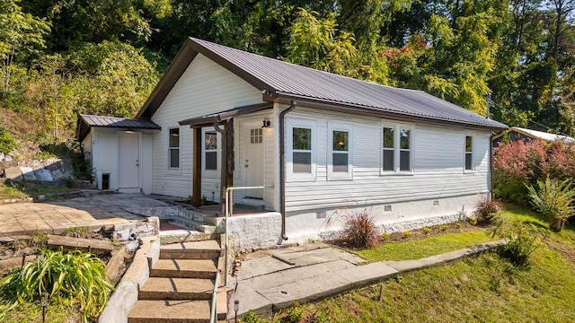 view of front of home featuring metal roof, crawl space, and a patio area