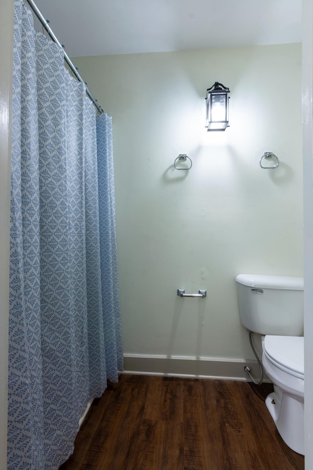 bathroom with toilet, hardwood / wood-style floors, and a shower with curtain