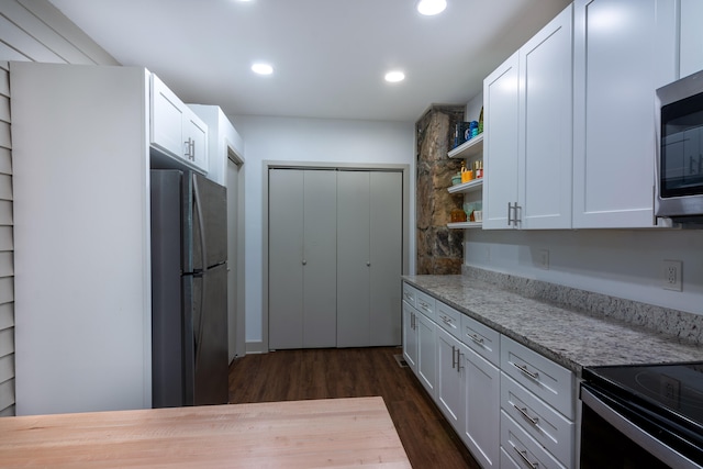 kitchen featuring white cabinets, light stone countertops, stainless steel appliances, and dark hardwood / wood-style floors